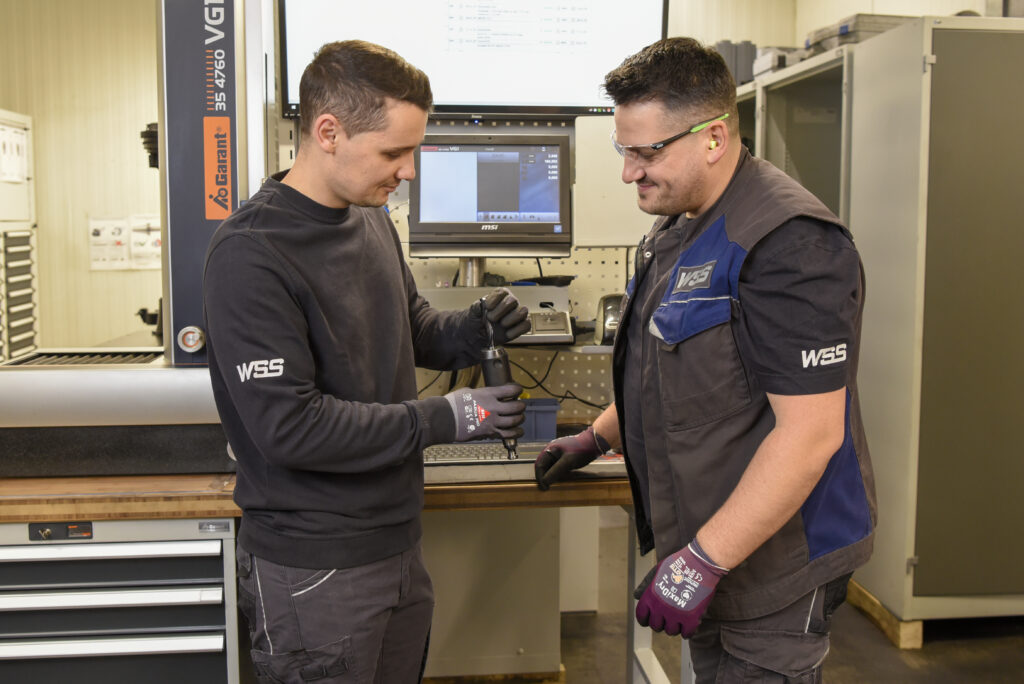 zwei Mitarbeiter untersuchen gemeinsam einen Bohrkopf