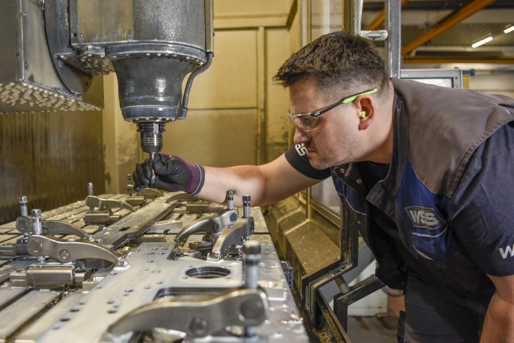 Maschinist arbeitet konzentriert an Metallbearbeitungsmaschine