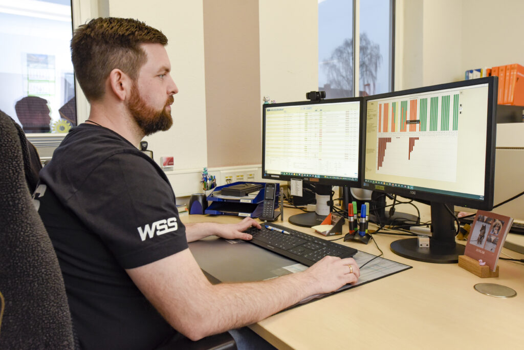 Mitarbeiter von WSS Metalltechnik arbeitet am Computer und bearbeitet Daten